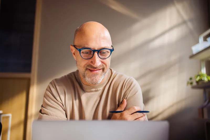 A man using his laptop at home to access healthy lifestyle support online.
