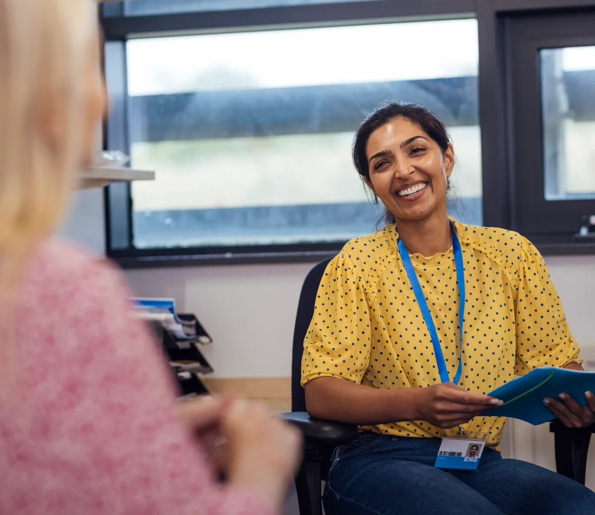 A stop smoking adviser smiling as she supports a client during a one-to-one session.